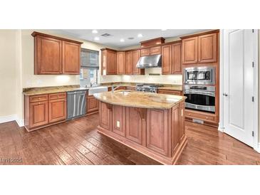 A chef's kitchen is complete with stainless appliances, an island, and custom cabinetry at 1 Corte Belleza, Henderson, NV 89011