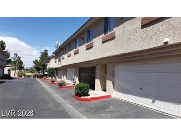 Exterior view of condo featuring private garage with white door and red-painted trim at 1236 Dusty Creek St, Las Vegas, NV 89128