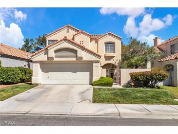 Charming two-story home with a well-manicured lawn, two-car garage, and gated front entry at 1825 Derbyshire Dr, Las Vegas, NV 89117
