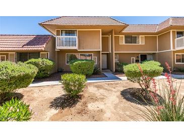 Two-story townhome showcasing manicured bushes, and a tiled roof at 2454 Paradise Village Way, Las Vegas, NV 89120