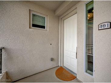 Entry to unit 401 featuring white door, small window, and a view through the side window at 9201 Tesoras Dr # 401, Las Vegas, NV 89144