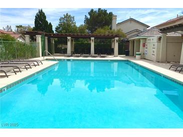 A beautiful community pool with lounge chairs and shaded pergola, perfect for relaxation and recreation at 9236 Canalino Dr, Las Vegas, NV 89134