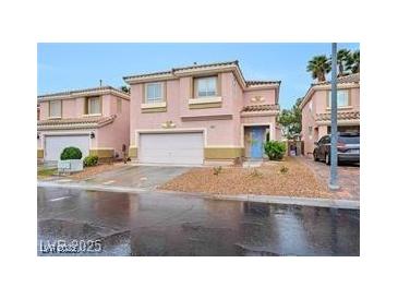 Two story home with a two car garage, desert landscaping, and a blue front door at 9247 Tulip Trestle Ave, Las Vegas, NV 89148