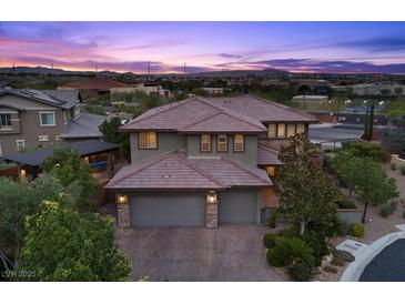 Beautiful two-story home featuring a three-car garage, lush landscaping and picturesque sunset views at 10470 Dove Meadow Way, Las Vegas, NV 89135