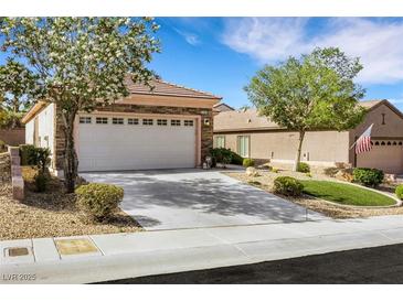 Charming single-story home with a two-car garage, lush landscaping, and inviting curb appeal at 2485 Jade Sky St, Henderson, NV 89044