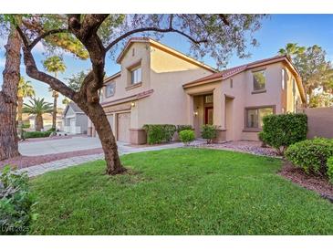 Charming two-story home featuring a lush green lawn, desert landscaping, and a warm, inviting facade at 249 Gentle Springs Dr, Henderson, NV 89012