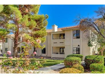 Inviting condo building exterior with mature landscaping and sidewalks, perfect for relaxing outdoors at 2633 S Durango Dr # 201, Las Vegas, NV 89117