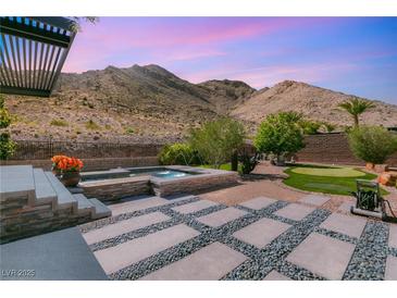 Stunning backyard with pool, jacuzzi, putting green, and mountain views at 2927 The Peaks Ln, Las Vegas, NV 89138