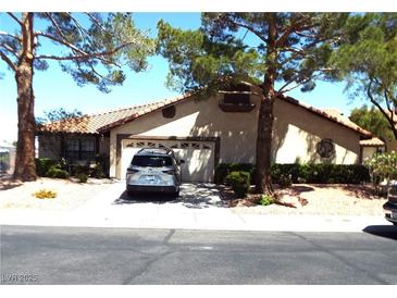 Charming single-story home featuring a tile roof, two-car garage and mature landscaping at 3954 Saddlewood Ct, Las Vegas, NV 89121