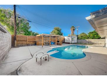 Backyard pool area featuring diving board, mature trees, and shaded outdoor entertaining space at 4284 Parkdale Ave, Las Vegas, NV 89121