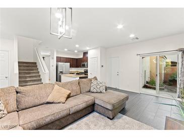 Bright living room features neutral colors, modern lighting, tile flooring, and direct access to the outdoor living space at 4533 Lime Straight Dr, Las Vegas, NV 89115