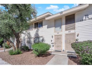 Charming townhouse featuring a well-kept front yard with mature trees and landscaping at 4770 Topaz St # 108, Las Vegas, NV 89121