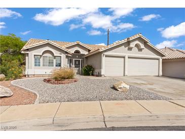 Charming single-story home featuring a two-car garage and low maintenance desert landscaping in front at 556 Decidedly St, Henderson, NV 89015