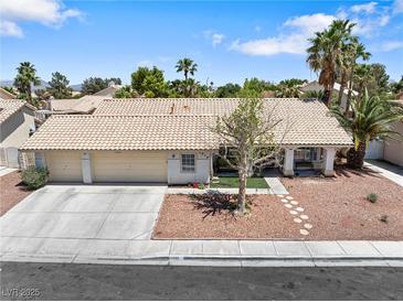 Charming single-story home featuring a well-maintained front yard and a three-car garage at 5912 Hollowridge Rd, North Las Vegas, NV 89031