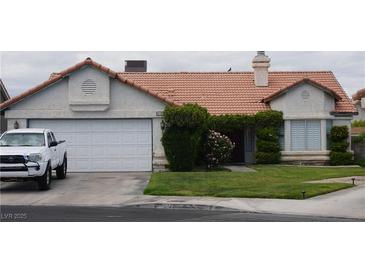 Charming single story home with a two car garage, red tile roof, and front yard with mature landscaping at 6432 Jean Lee Dr, Las Vegas, NV 89108
