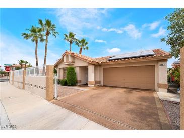 Inviting single-story home with a two-car garage, desert landscaping, and solar panels for energy efficiency at 988 Flapjack Dr, Henderson, NV 89014