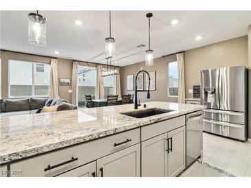 Bright kitchen with granite countertops, pendant lighting, stainless steel appliances, and view into the dining area at 10190 Natural Anchor St, Las Vegas, NV 89166