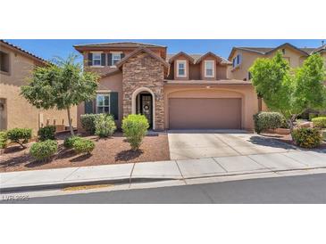 Charming two-story home featuring a stone facade, manicured landscaping, and attached two-car garage at 10353 Settlers Run Ave, Las Vegas, NV 89166