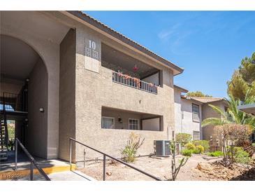 Exterior view of condo building with desert landscaping and stucco facade at 2606 S Durango Dr # 122, Las Vegas, NV 89117