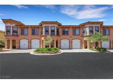 Attractive townhome complex featuring garages, neat landscaping, and an appealing architectural style with neutral paint at 30 Via Vasari # 102, Henderson, NV 89011