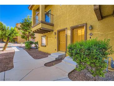 Inviting townhouse exterior with a cozy balcony, well-maintained landscape, and pathway leading to the entrance at 5915 Nuevo Leon St # 8, North Las Vegas, NV 89031