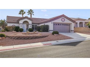Charming single-story home showcasing well-maintained landscaping and a two-car garage at 9921 Woodhouse Dr, Las Vegas, NV 89134
