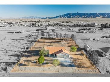 Expansive aerial view of desert home with an orange roof and mountain views at 1601 Iguana St, Pahrump, NV 89048