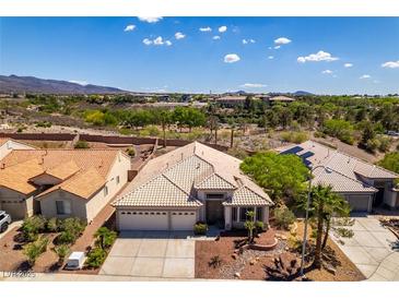 Spacious home boasts well-manicured landscaping and a neutral color palette, complemented by desert views at 2587 Grizzly Park Ct, Henderson, NV 89052