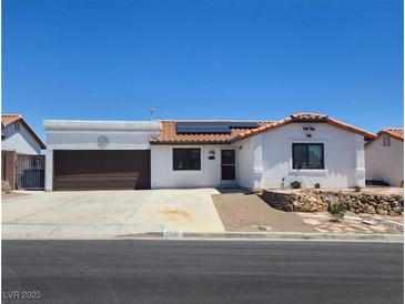 Charming single-story home with white stucco exterior, brown garage door, and desert landscaping at 2822 La Palma Dr, Laughlin, NV 89029