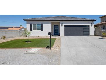 Charming single-story home featuring desert landscaping and a modern garage door at 3440 Ernest St, North Las Vegas, NV 89032