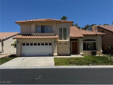 Two-story home featuring a two-car garage, desert landscaping and a red tile roof at 5024 Saint Annes Dr, Las Vegas, NV 89149
