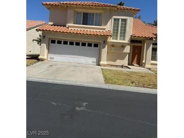 Charming stucco home with a two-car garage, red tile roof, and well-manicured lawn at 5024 Saint Annes Dr, Las Vegas, NV 89149