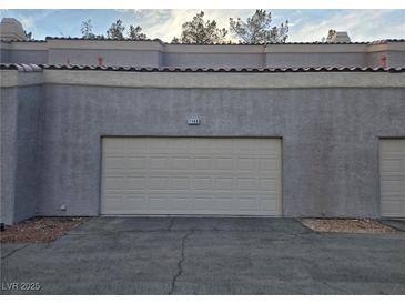 Attached garage door and exterior features a tiled roof in this multi-Gathering residence at 5250 S Rainbow Blvd # 1140, Las Vegas, NV 89118