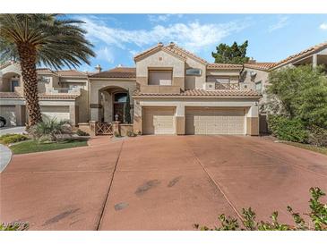 Attractive two-story home featuring a terracotta-colored driveway, a two-car garage and lush landscaping at 56 Grossinger Ct, Henderson, NV 89074