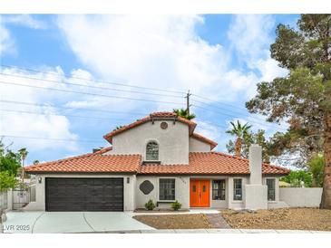 Charming two-story home with a terra cotta tile roof, and an inviting entrance featuring vibrant orange doors at 5757 Charles Holden Ct, Las Vegas, NV 89103
