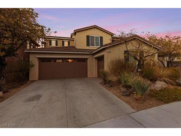 Inviting two-story home featuring a spacious driveway and a well-manicured desert landscape at 7438 Desertscape Ave, Las Vegas, NV 89178