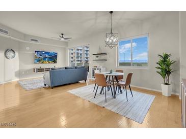 Bright living room featuring a ceiling fan, flatscreen TV, wood floors, and dining area at 8255 One Las Vegas Blvd # 504, Las Vegas, NV 89123