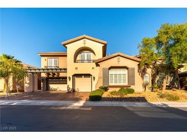 Charming home featuring an arched balcony, three-car garage, and desert landscaping at 10002 Trapper Mountain St, Las Vegas, NV 89178