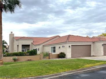 Charming single-story home with well-maintained lawn, desert landscaping, and an attached two car garage at 1198 Golf Club, Laughlin, NV 89029