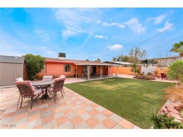 Spacious backyard featuring green lawn, covered patio, and outdoor seating area at 147 Cervantes St, Las Vegas, NV 89101