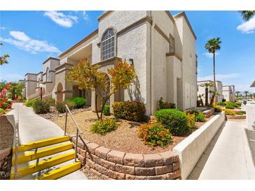Charming condo building featuring well-maintained landscaping and exterior staircase at 3150 Soft Breezes Dr # 1037, Las Vegas, NV 89128