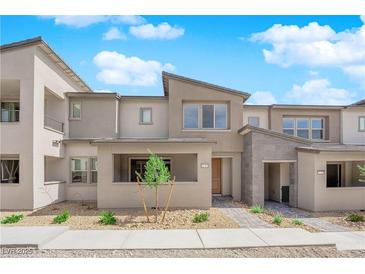 A modern townhome showcasing a neutral color palette, drought-resistant landscaping, and a charming covered entry at 11407 Ethereal Landing Ave, Las Vegas, NV 89138