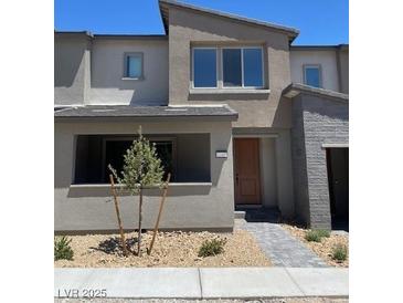 Contemporary townhouse featuring desert landscaping and a neutral color palette at 11407 Ethereal Landing Ave, Las Vegas, NV 89138