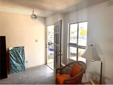 View of the living room with a window, furniture, and front door at 212 Hinkle St, Las Vegas, NV 89107