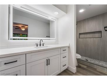 Modern bathroom features an illuminated mirror, stylish vanity, and walk-in shower at 3260 Longford Way, Las Vegas, NV 89121