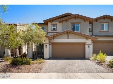 Inviting two-story townhome with a charming facade, two car garage and well-manicured landscaping at 329 Brockbank Pl, Henderson, NV 89011