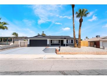 Charming single-story home with a dark-gray two-car garage and low maintenance desert landscaping at 4442 Bennett Dr, Las Vegas, NV 89121