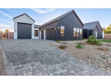 Modern home showcasing a stylish garage and a paved driveway, with desert landscaping at 5725 El Royale Ct, Las Vegas, NV 89149