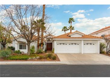 Charming single-story home with a three-car garage, mature trees, and desert landscaping at 1933 Davina St, Henderson, NV 89074