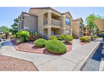 Attractive apartment building with well-manicured landscaping and inviting walkways on a sunny day at 2300 E Silverado Ranch Blvd # 1165, Las Vegas, NV 89183